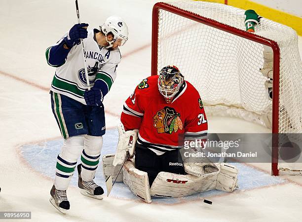 Antti Niemi of the Chicago Blackhawks knocks away the puck in front of Ryan Kesler of the Vancouver Canucks in Game Five of the Western Conference...