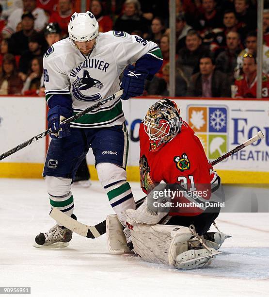 Antti Niemi of the Chicago Blackhawks makes a save as Jannik Hansen of the Vancouver Canucks plays in close in Game Five of the Western Conference...