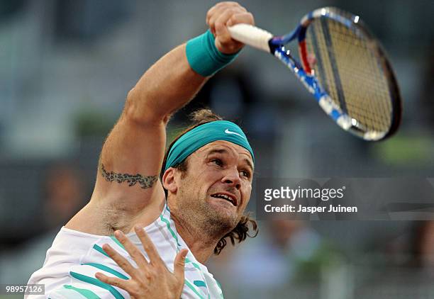 Carlos Moya of Spain serves the ball to Benjamin Becker of Germany in their first round match at the Mutua Madrilena Madrid Open tennis tournament at...