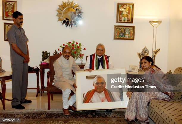 Former Prime Minister Atal Bihari Vajpayee shows a photo of himself presented by BJP general secretary Vijay Goel, on June 24, 2008 in New Delhi,...