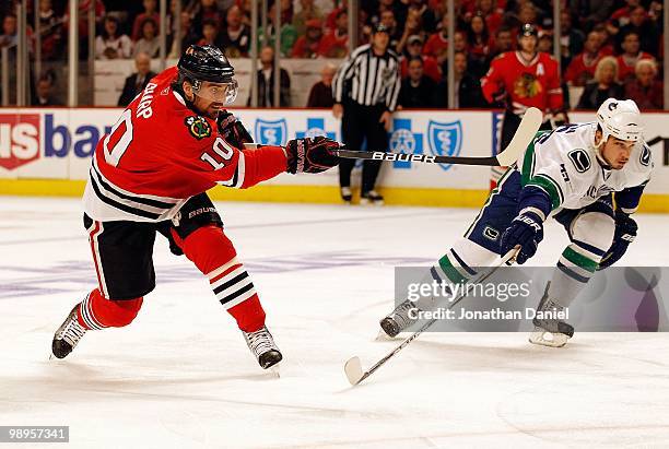 Patrick Sharp of the Chicago Blackhawks shoots the puck as Shane O'Brien of the Vancouver Canucks pushes his stick in the way in Game Five of the...