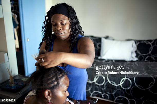Lyresh Magee does a friend's hair in her one room apartment April 21, 2010 in the newly opened Charles Cobb Apartments in Los Angeles, California....