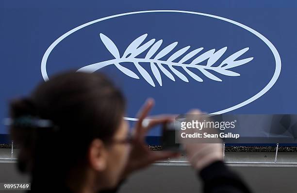 Young woman snaps a picture near the Golden Palm symbol outside the Palais des Festivals prior to the annual film festival on May 10, 2010 in Cannes,...