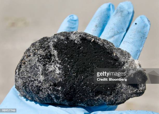 Five-inch-wide oil tar ball is displayed for a photo after being found on the west end shore of Dauphil Island, Alabama, U.S., on Sunday, May 9,...