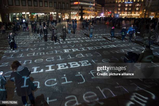 'Liebe und Frieden' is projected to the ground next to other words as part of a light installation at the Domplatte square in Cologne, Germany, 30...