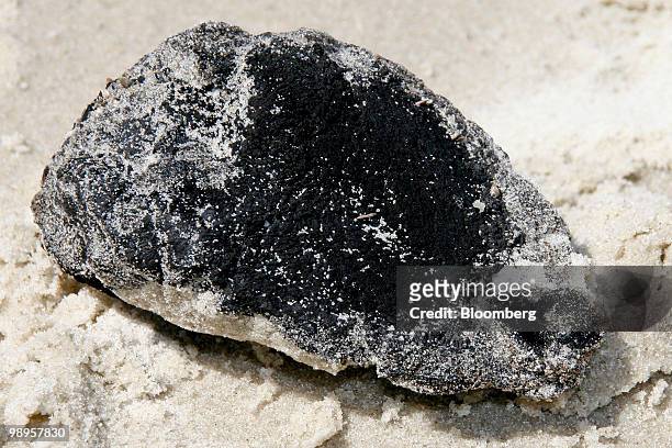 Five-inch-wide oil tar ball sits on the west end shore of Dauphin Island, Alabama, U.S., on Sunday, May 9, 2010. Oil has been gushing from the...