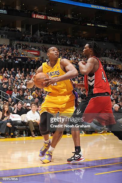 Andrew Bynum of the Los Angeles Lakers puts a shot up against Chris Bosh of the Toronto Raptors at Staples Center on March 9, 2010 in Los Angeles,...