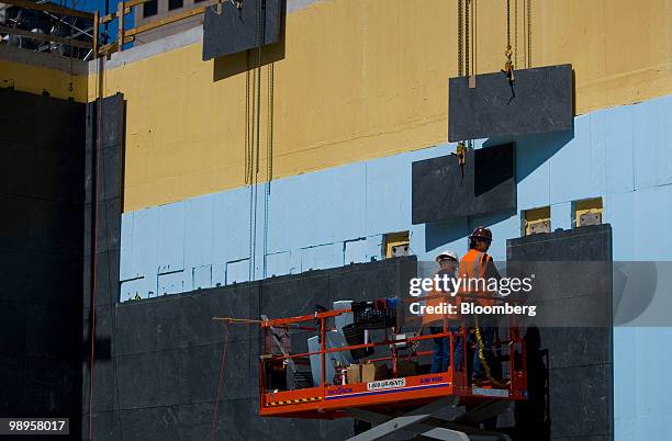 Workers hang slate on the north memorial pit wall at the World Trade Center construction site in New York, U.S., on Monday, May 10, 2010. One World...