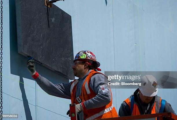 Workers hang slate on the north memorial pit wall at the World Trade Center construction site in New York, U.S., on Monday, May 10, 2010. One World...