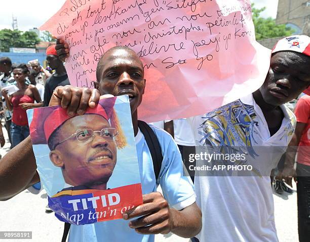 Haitian holds their exiled President, Jean-Bertrand Aristide, photo during a demonstration on May 10, 2010 in Port-au-Prince against their President...