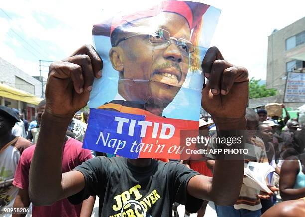 Haitian holds their exiled President, Jean-Bertrand Aristide, photo during a demonstration on May 10, 2010 in Port-au-Prince against their President...