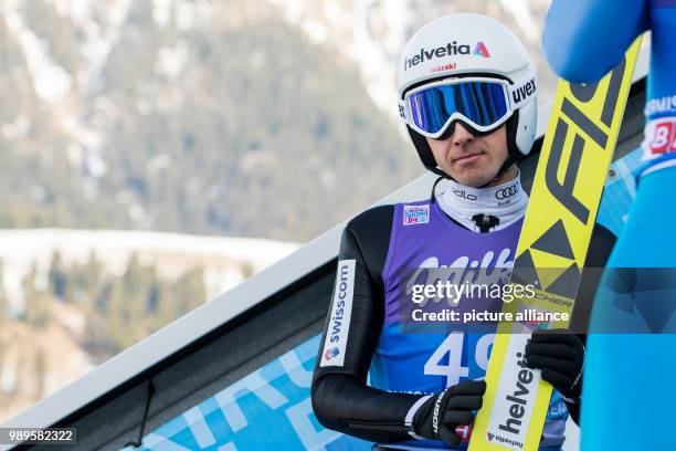 Simon Amman of Switzerland sitting during the trial round of the men's large hill ski jumping event at the Four Hills Tournament in...