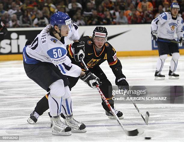 Germany's Michael Wolf vies with Finland's Juhamatti Aaltonen during the IIHF Ice Hockey World Championship match Germany vs Finland in the western...