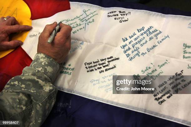 Soldier signs a Colorado flag for soldiers deploying to Afghanistan on May 10, 2010 in Centennial, Colorado. A dozen Colorado Army National guardsmen...
