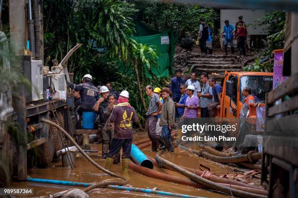 Rescue workers work on the water pumping machine at the entrance of Tham Luang Nang Non cave on July 2, 2018 in Chiang Rai, Thailand. Rescuers from...