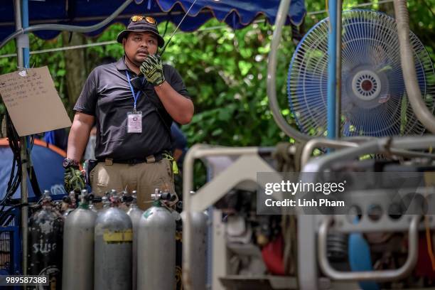 Rescuer checks the scube tanks at the makeshift camp at Khun Nam Nang Non Forest Park divers prepare the underwater light on July 2, 2018 in Chiang...