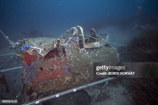 Mapping lines are laid by divers from the FS Pluton M622 navy de-mining ship, swims on July 2 above the wreck of an USAAF P-47 Thunderbolt US fighter...