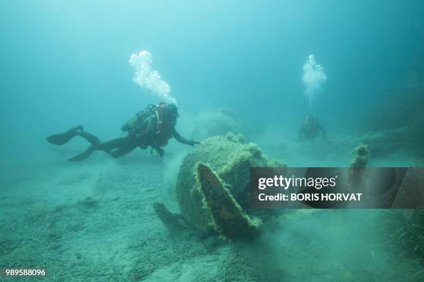 French military diver member of the FS Pluton M622 navy de-mining ship, swims on July 2 above the wreck of an USAAF P-47 Thunderbolt US fighter...