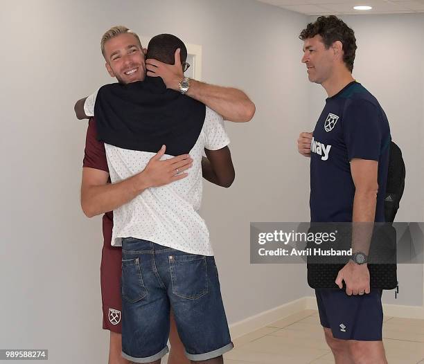 Pedro Obiang of West Ham United is greeted by Adrian San Miguel during the first day back of pre-season at Rush Green on July 2, 2018 in Romford,...