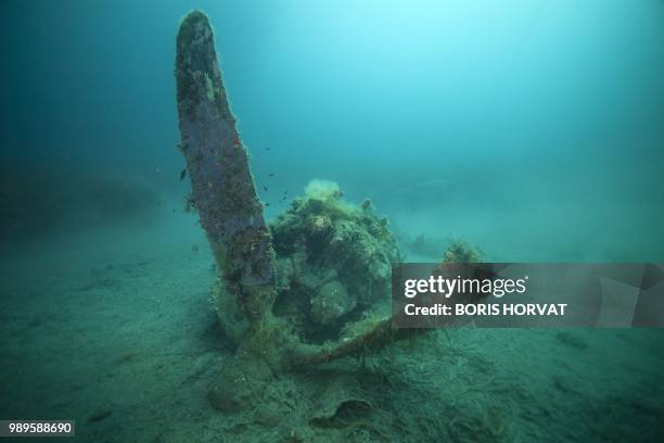 French military diver member of the FS Pluton M622 navy de-mining ship, swims on July 2 above the wreck of an USAAF P-47 Thunderbolt US fighter...