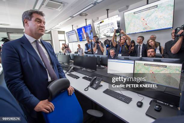 Bavaria's State Premier Markus Soeder of the conservative Christian Social Union party inspects the operation centre during an event on the new...