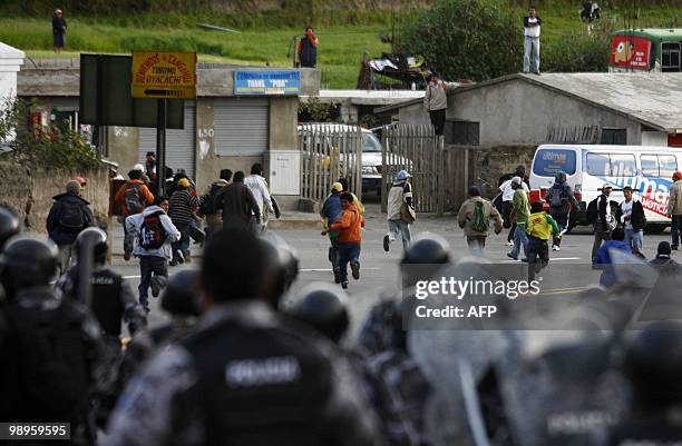 Ecuadorean natives run during clashes with the police in Guachala, some 30 km from Quito, on May 10, 2010 in protest of a proposed water...