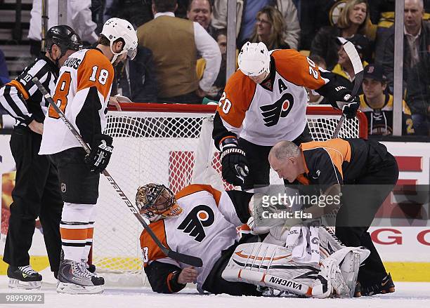 Brian Boucher of the Philadelphia Flyers attended to by teammates Chris Pronger and Mike Richards after he was injured in the second period against...