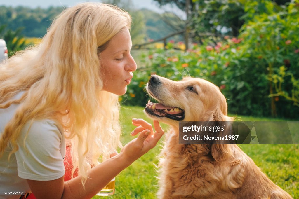 Giovane donna che gioca con il suo cane all'aperto.