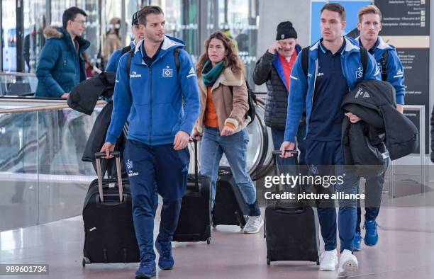 The players of the Hamburger SV soccer club, Dennis Diekmeier , goalkeeper Christian Mathenia and Andre Hahn walk through the departure terminal at...