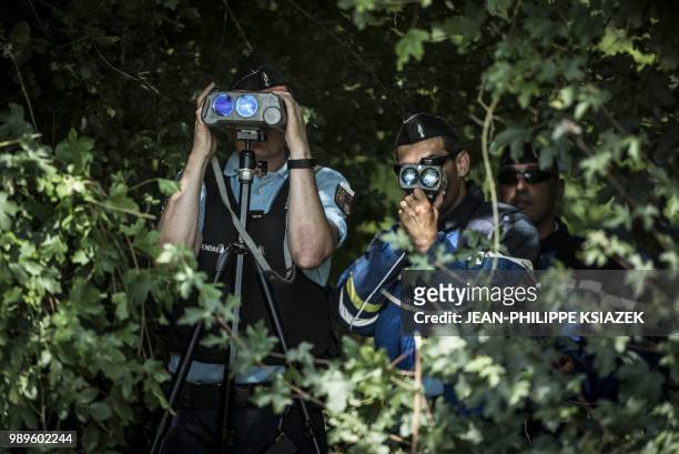French gendarmes look through speed cameras during an educational speed control on a secondary road with a newly imposed speed limit of 80 kmph, on...