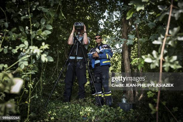 French gendarme looks through a speed camera during an educational speed control on a secondary road with a newly imposed speed limit of 80 kmph, on...
