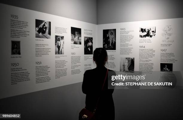 Woman looks at a timeline at the exhibition "L'Alchimie Secrete d'Une Collection" of late French-Tunisian fashion designer Azzedine Alaia on July 2,...