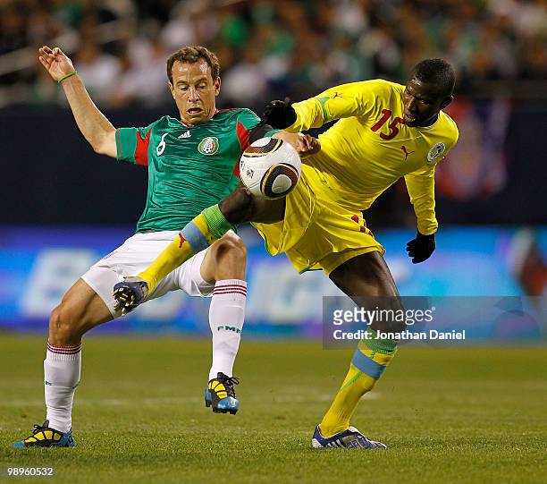 Mame Saher of Senegal tries to control the ball under pressure from Gerardo Torrado of Mexico during an international friendly at Soldier Field on...