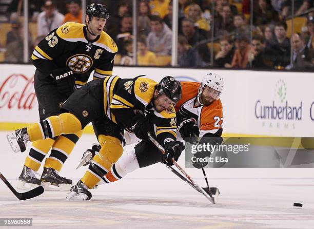 Trent Whitfield of the Boston Bruins and Ville Leino of the Philadelphia Flyers fight for the puck in Game Five of the Eastern Conference Semifinals...