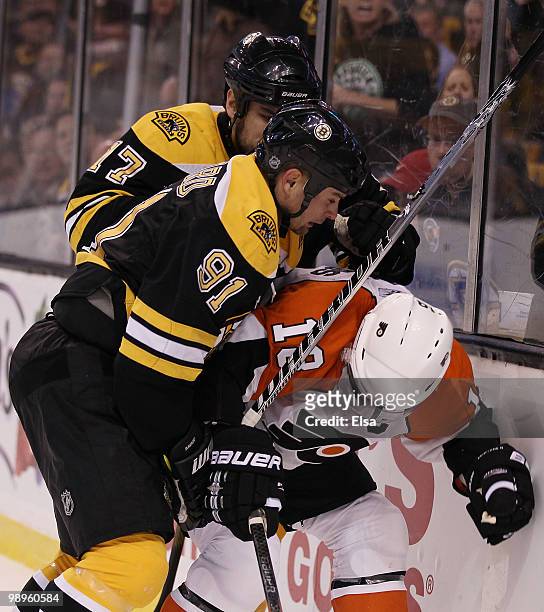Marc Savard and Milan Lucic of the Boston Bruins shove Mike Richards of the Philadelphia Flyers in Game Five of the Eastern Conference Semifinals...