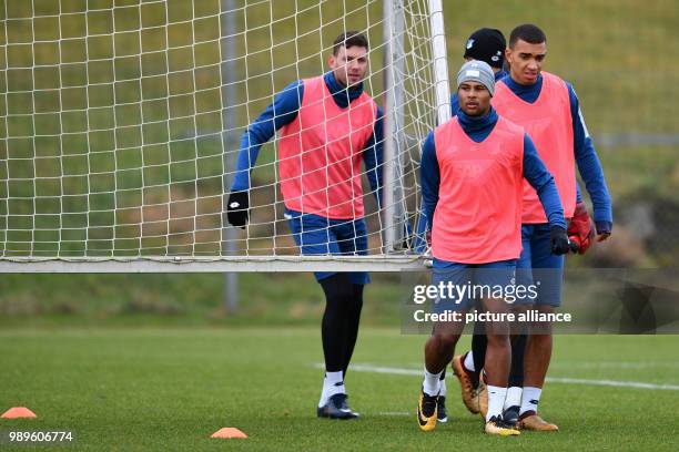 Hoffenheim's Adam Szalai , Serge Gnabry and Kevin Akpoguma carry a small goal over the training ground during the training of 1899 Hoffenheim in...