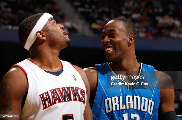 Dwight Howard of the Orlando Magic enjoys a laugh at a parody about him on the big screen next to Josh Smith of the Atlanta Hawks during Game Four of...