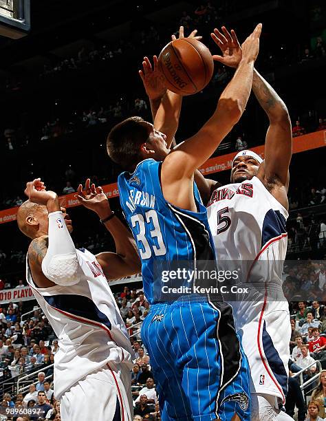 Maurice Evans and Josh Smith of the Atlanta Hawks force a turnover by Ryan Anderson of the Orlando Magic during Game Four of the Eastern Conference...