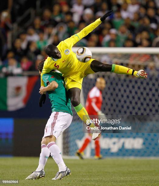 Moustapha Cisse of Senegal leaps for the ball and lands on the back of Hector Moreno of Mexico during an international friendly at Soldier Field on...