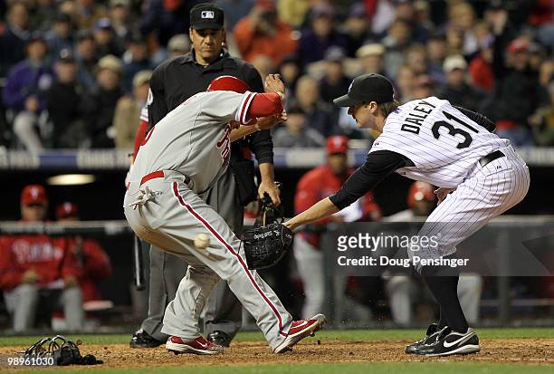 Shane Victorino of the Philadelphia Phillies scores on a wild pitch by pitcher Matt Daley of the Colorado Rockies as Daley covers the plate and takes...
