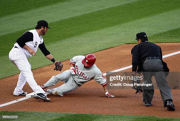 Shane Victorino of the Philadelphia Phillies slides safely into third base ahead of the tag of Ian Stewart of the Colorado Rockies for a first inning...