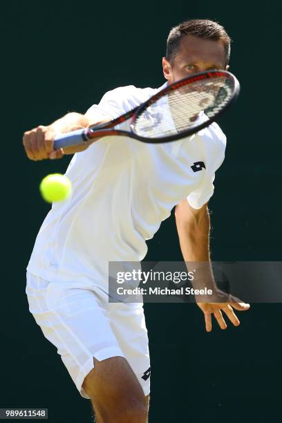 Sergiy Stakhovsky of Ukraine returns to Joao Sousa of Portugal during their Men's Singles first round match on day one of the Wimbledon Lawn Tennis...