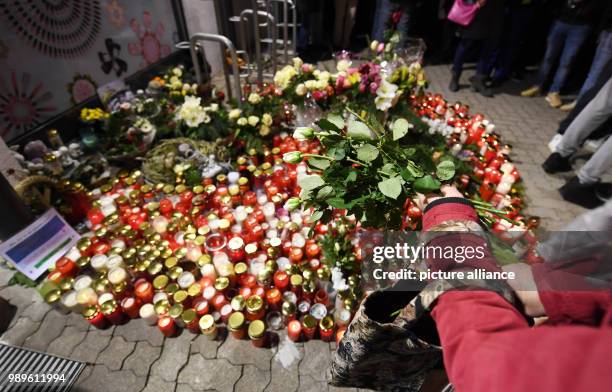 Mourners place flowers and candles in front of a drug store in memory a 15-year-old girl, who was stabbed by her boyfriend in the store, in Kandel,...