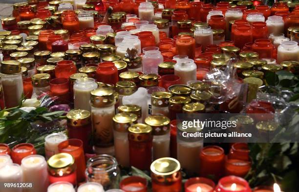 Flowers and candles lie in front of a drug store in memory a 15-year-old girl, who was stabbed by her boyfriend in the store, in Kandel, Germany, 02...