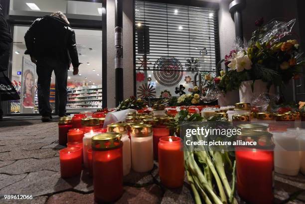 Flowers and candles lie in front of a drug store in memory a 15-year-old girl, who was stabbed by her boyfriend in the store, in Kandel, Germany, 02...