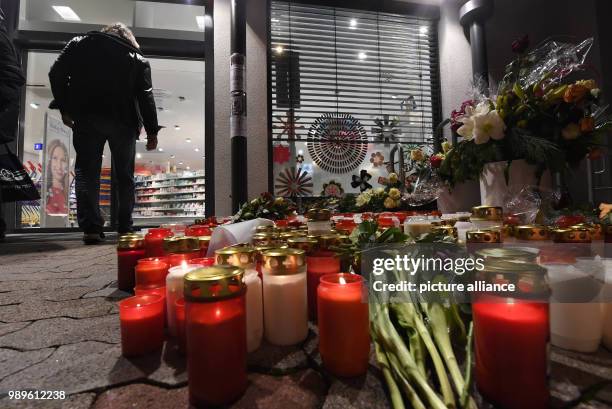 Flowers and candles lie on the ground in front of a drug store in memory of a 15-year-old girl, who was allegedly stabbed by her ex-boyfriend at the...