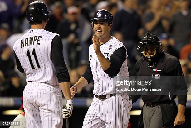 Seth Smith of the Colorado Rockies is welcomed home by Brad Hawpe as he scores against the Philadelphia Phillies at Coors Field on May 10, 2010 in...