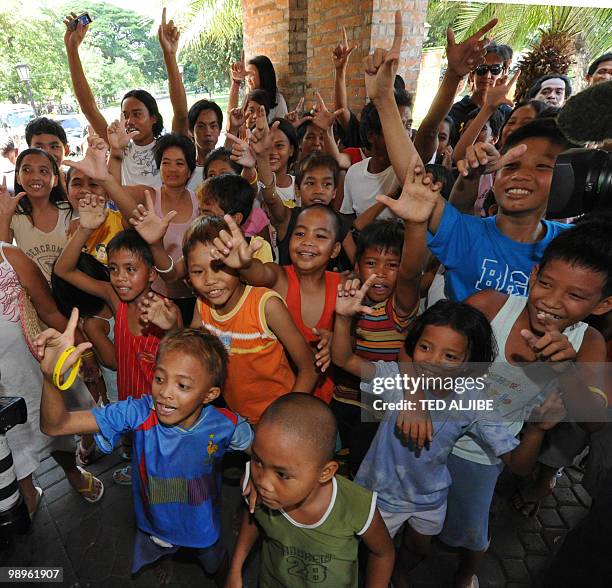 Supporters of Liberal party leading presidential candidate Benigno Aquino flash the "Laban" sign as they wait for him outside a restaurant in Tarlac...