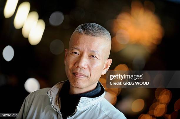 Chinese New York based artist Cai Guo-Qiang, stands in front of his work, "Inopportune:Stage One ", which shows suspended cars in an animated...