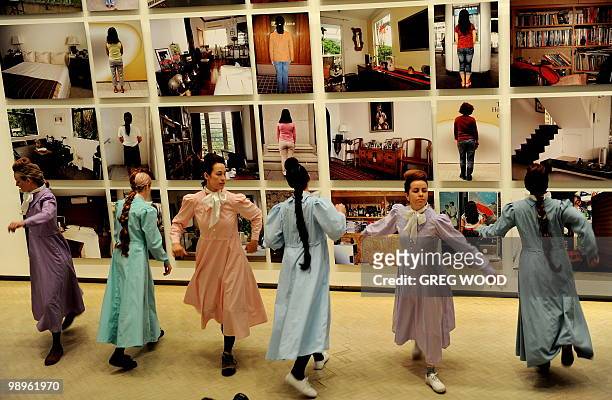 Performers dance in front of the work "Hong Kong Intervention " by Chinese artists Sun Yuan and Peng Yu, which forms part of the 17th Biennale of...